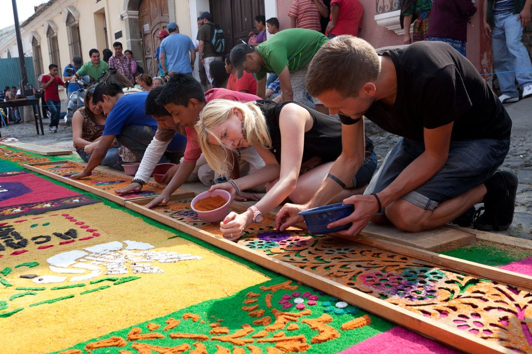 Sawdust and flower alfombra carpet on a cobblestone street during Semana Santa in Antigua Guatemala